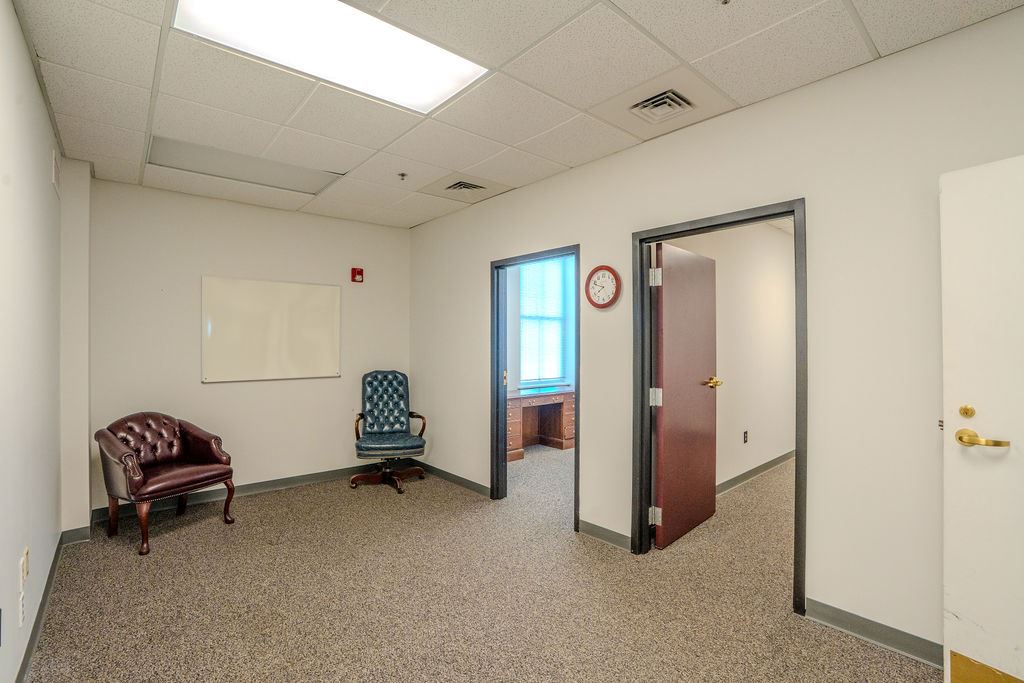 Room with two chairs and two doors that enter other rooms