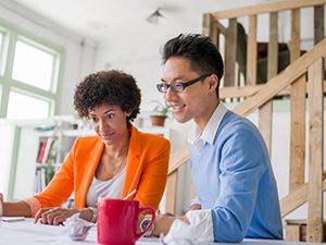 Woman and man sitting at Desk with Laptop
